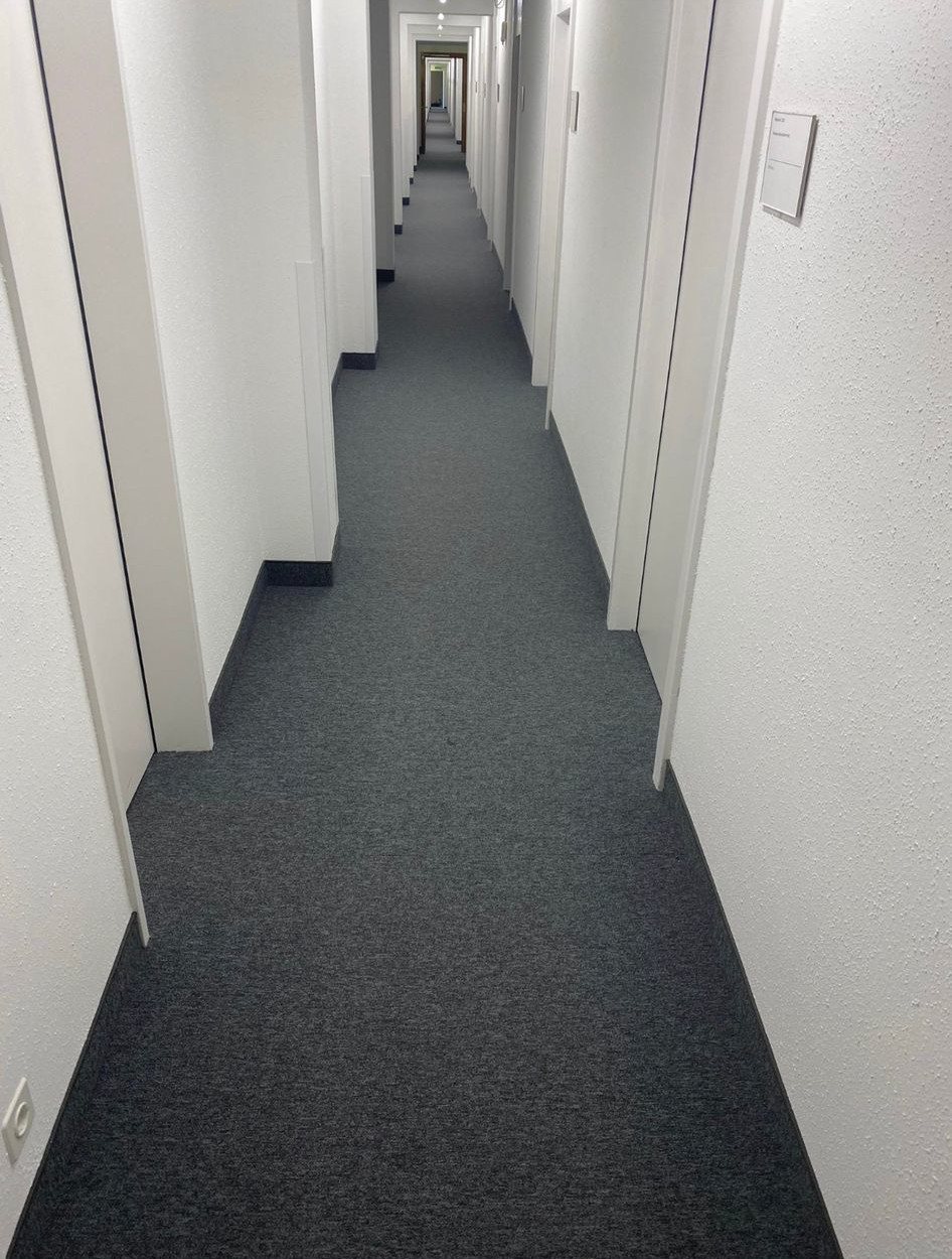 Spannteppich, Stiftung Diakoniewerk Neumünster: Dunkler Spannteppich in Korridoren und einem Sitzungszimmer