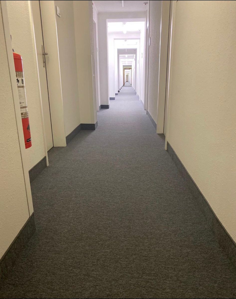 Spannteppich, Stiftung Diakoniewerk Neumünster: Dunkler Spannteppich in Korridoren und einem Sitzungszimmer