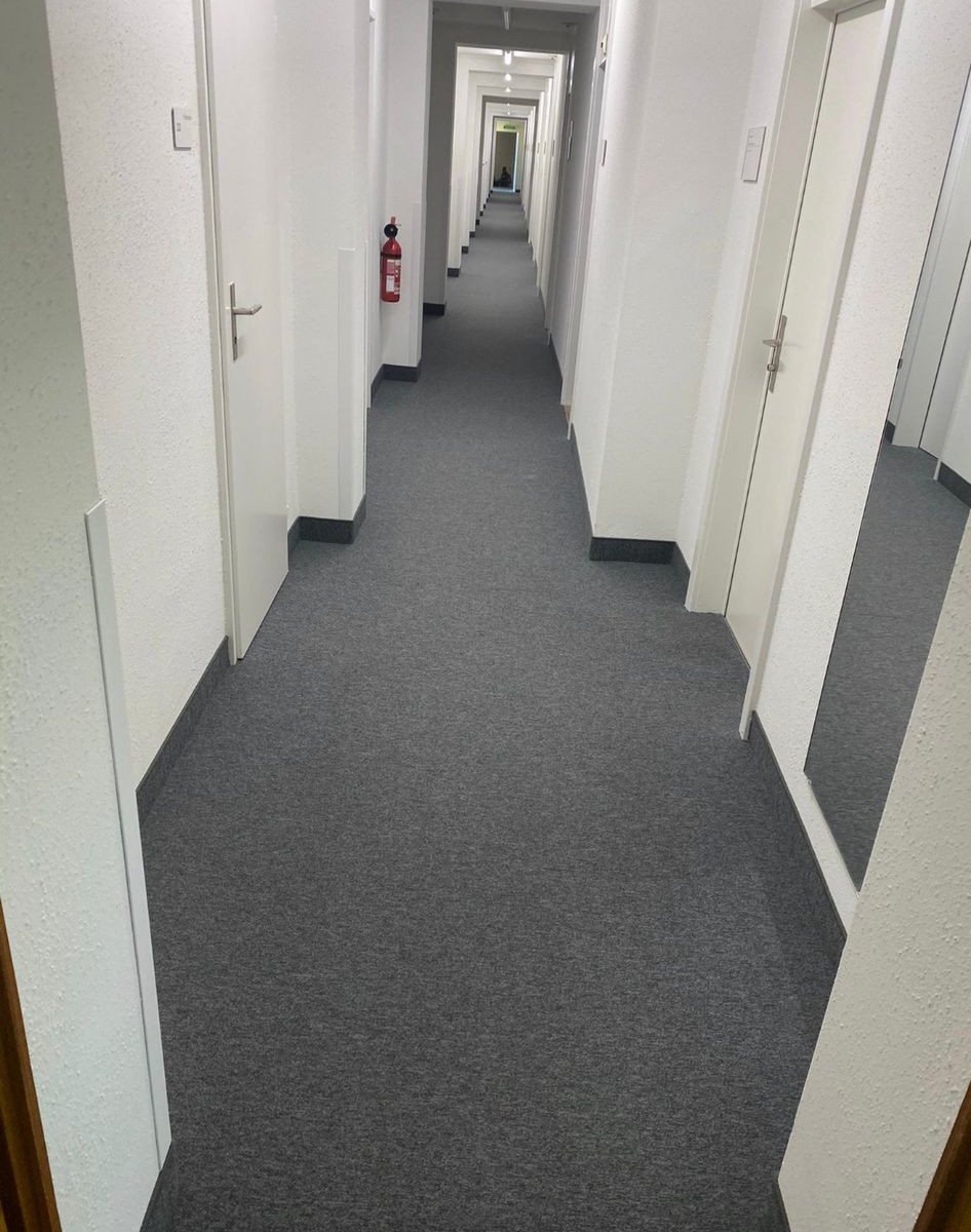 Spannteppich, Stiftung Diakoniewerk Neumünster: Dunkler Spannteppich in Korridoren und einem Sitzungszimmer